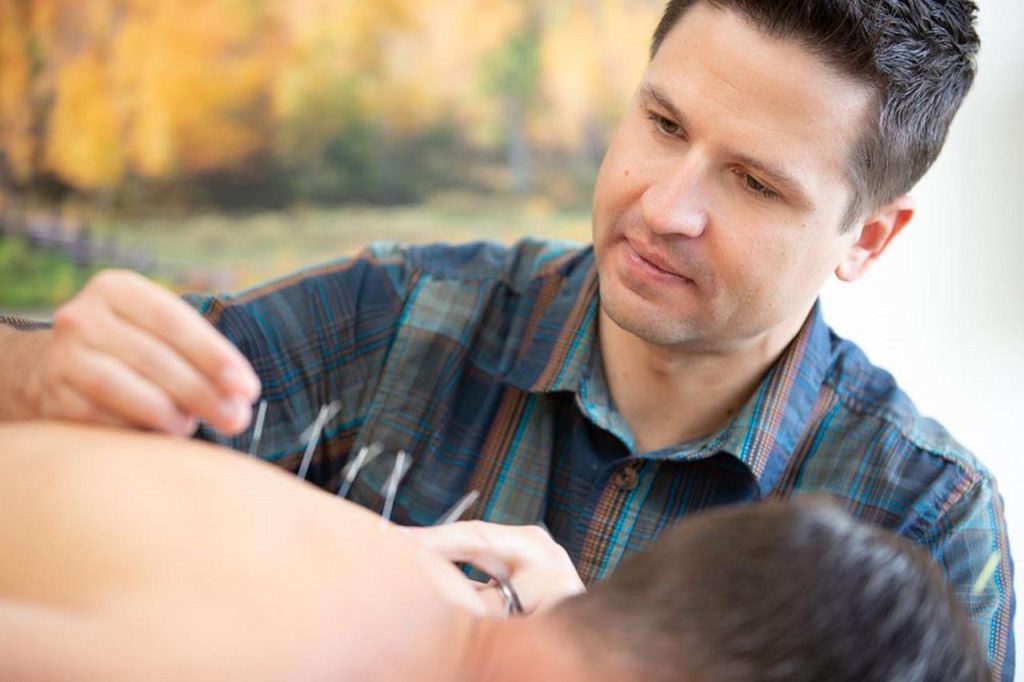 Acupuncturist in Heerlen voert behandeling uit met dunne naalden op specifieke lichaamspunten voor pijnverlichting en stress