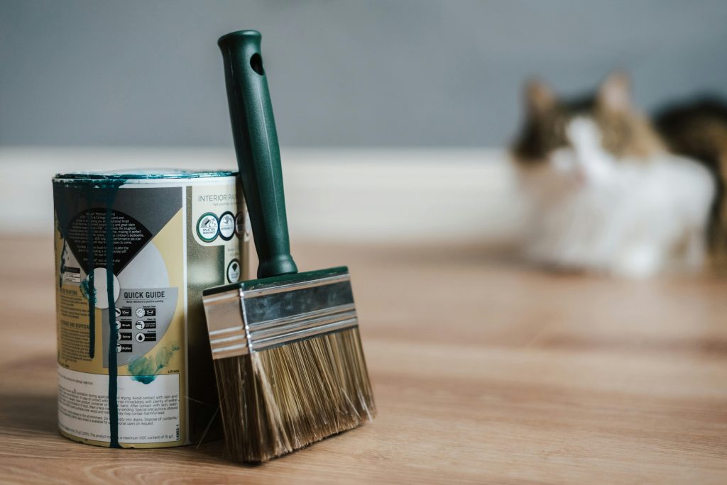 Voorbereiding en materialen voor het schilderen van je huis - kwasten, roller, schilderstape en verfpotten klaar voor gebruik