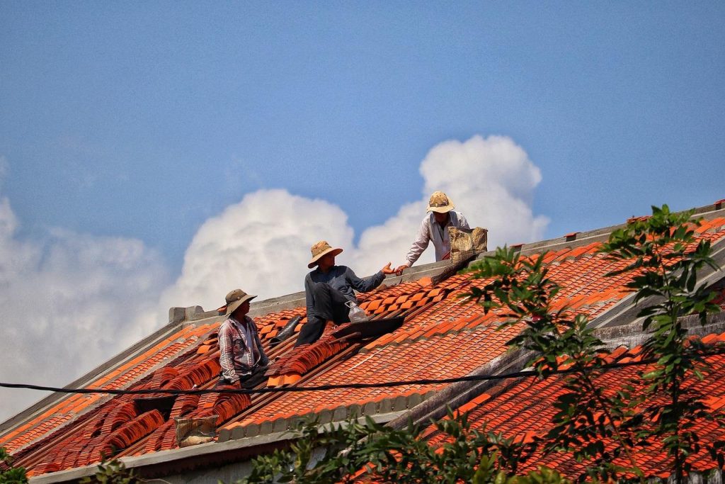 Professionele dakwerker in Woerden voert inspectie uit op dak met verschillende materialen en constructies